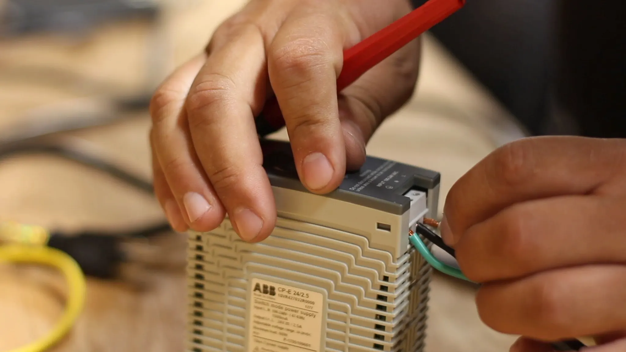 Electrician installing wire into relay.