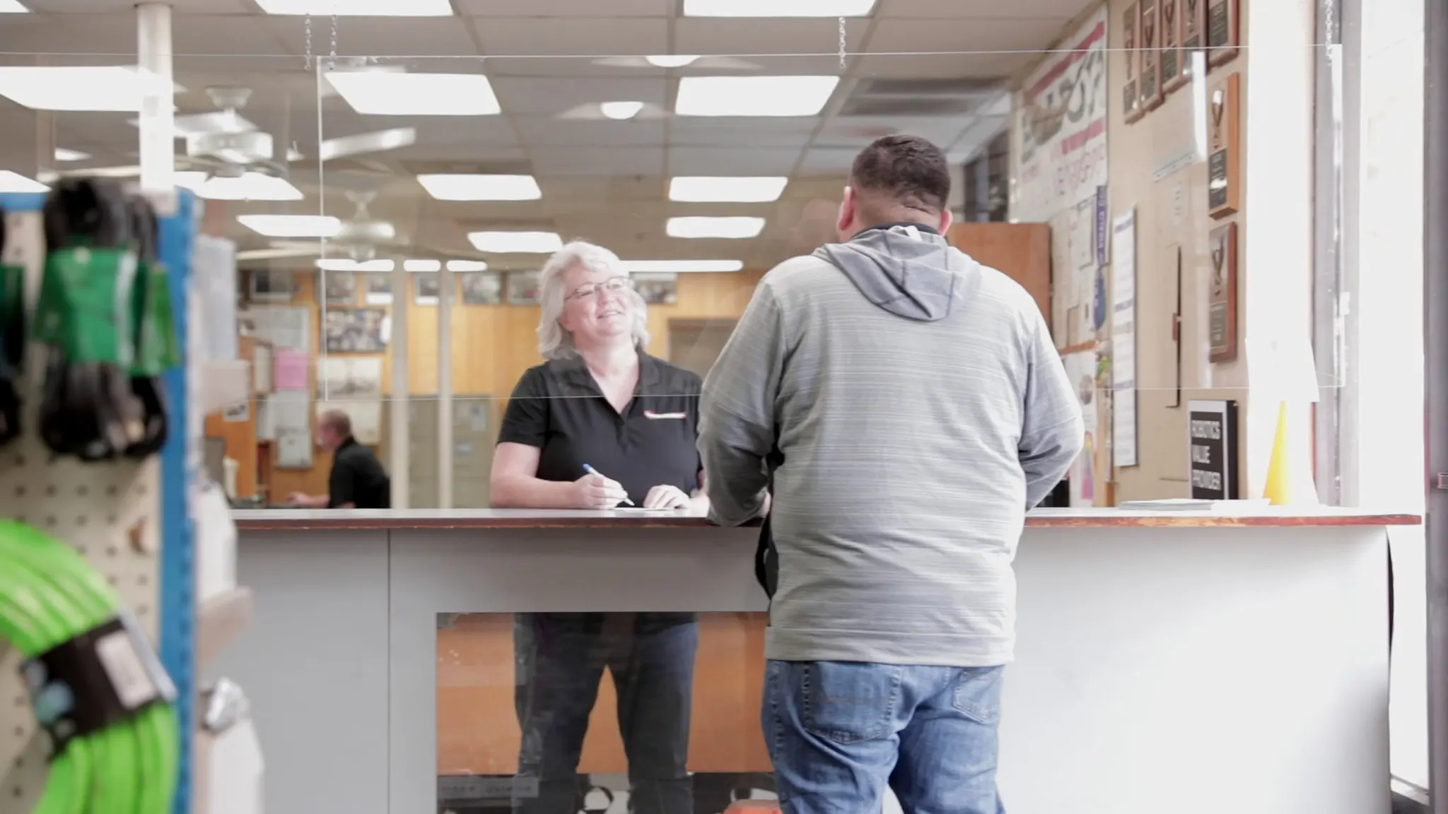 Employee speaking to customer at sales counter.