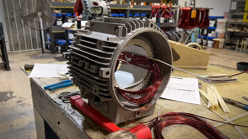 Rewinding electric motor with copper wire.