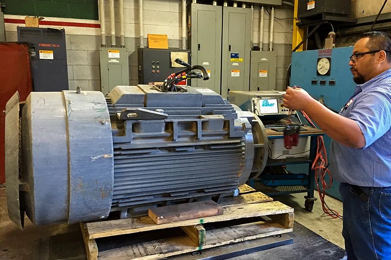 Electric Motor Shop technician performing initial static electrical testing on large industrial motor to assess insulation and winding condition.