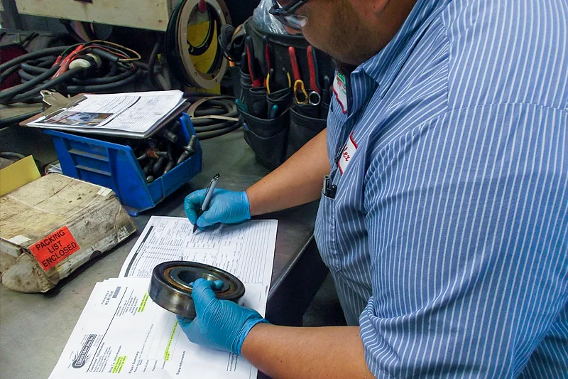 Electric Motor Shop technician recording bearing condition and inspection results during motor repair process.