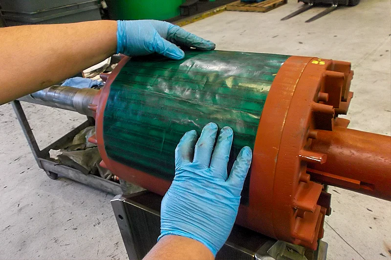 Technician inspecting rotor bars for electrical and mechanical integrity during motor evaluation process.