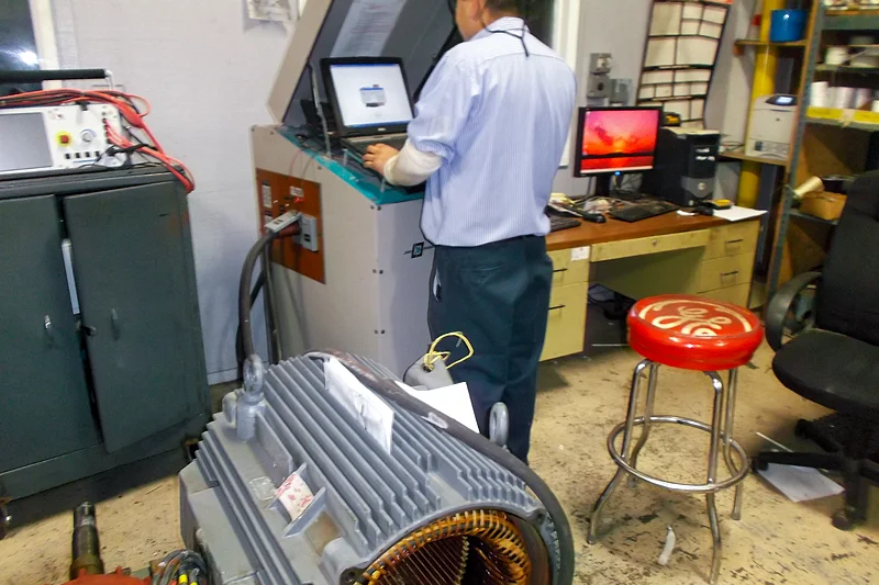 Electric Motor Shop technician performing computerized LEXSECO core loss test to detect iron damage before stator core reuse.