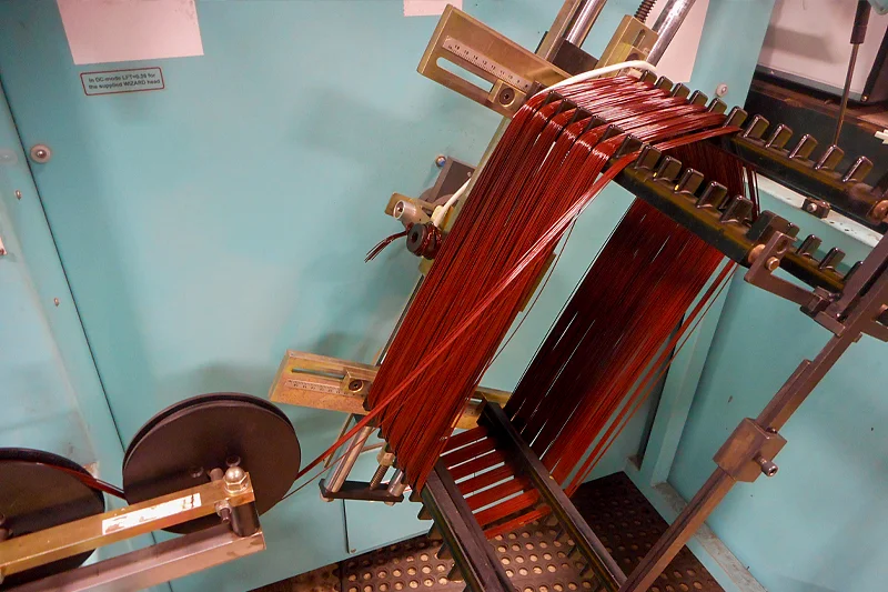 Close-up of new copper motor coils being precision-wound on SOMATIC coil machine at Electric Motor Shop.