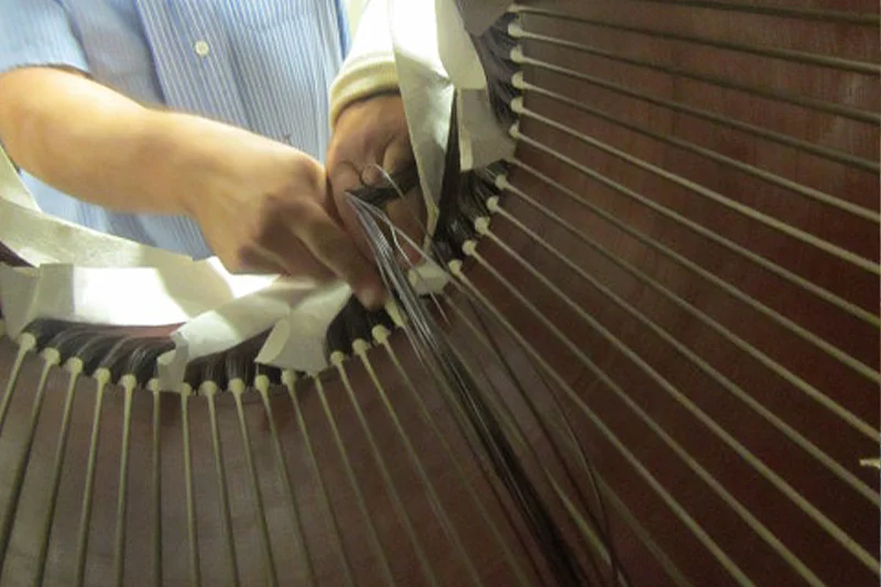 Technician connecting coil leads according to original winding design during motor rewind termination process.