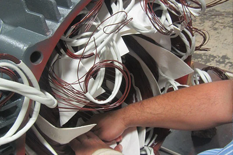 Coil end turns securely bundled with phase insulation in place, prepared for final electrical testing.