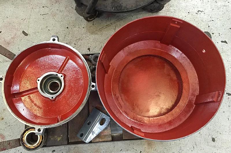 Close-up of two freshly painted red motor end bells placed side by side on the shop floor.