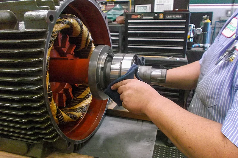Technician installing a bearing on the motor shaft during final reassembly of the electric motor.