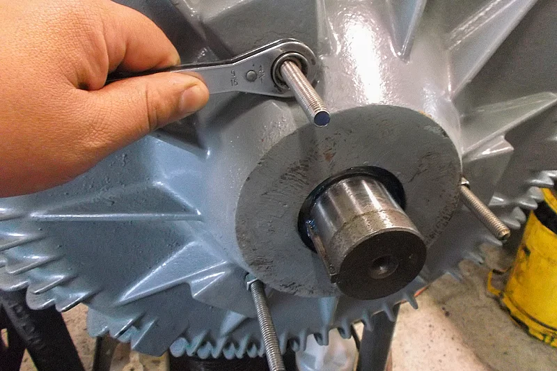 Technician applying touch-up spray paint to the motor’s exterior housing during the final reassembly phase.